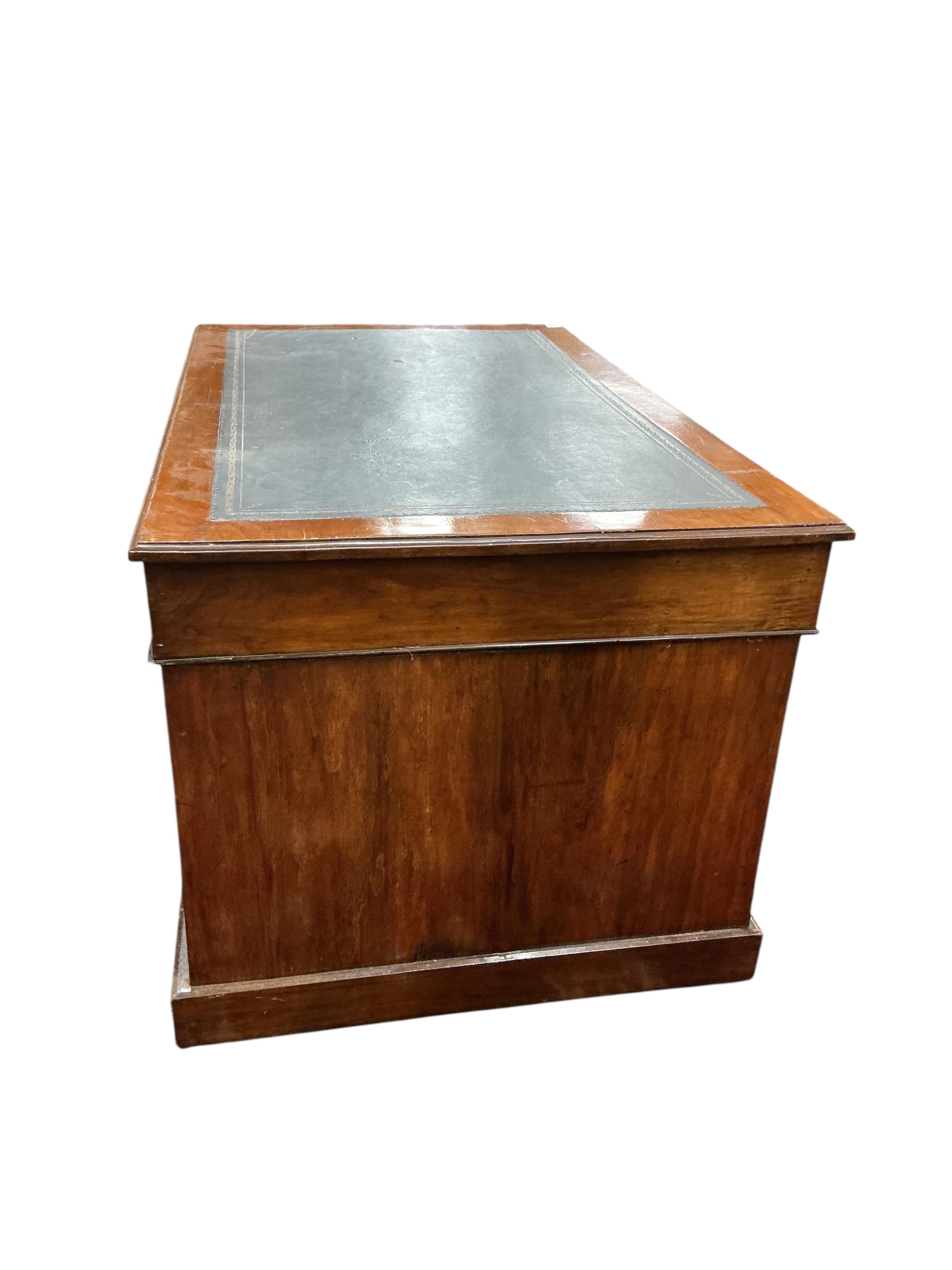 A late Victorian mahogany pedestal desk, fitted nine small drawers, width 138cm, depth 82cm, height 74cm